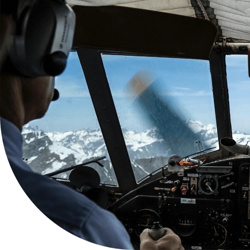 Pilot reaching up to the overhead switch panel in an airliner cockpit
